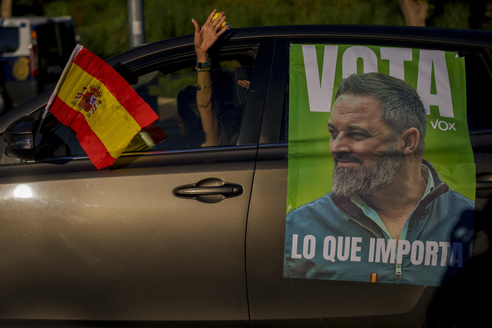 A woman drives her car with a picture of the VOX far right party leader Santiago Abascal before an election campaign event in Guadalajara, Spain, Saturday, July 15, 2023. Spain's elections Sunday will be a battle between two leftist and two rightist parties that are teaming up to form possible coalitions. Abascal likes to style himself as an outsider who has arrived on the mission to save Spain's soul. (AP Photo/Manu Fernandez)