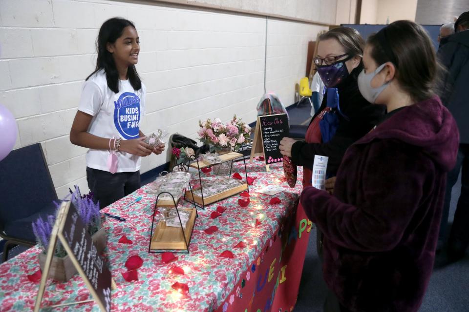 Aashi Mather, 11, of Westerville, helps Kim Fatten of Gahanna and her daughter, Sil Fatten, 11, browse soaps from her Serenique Soaps shop during the fair.