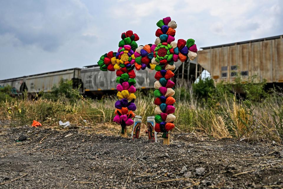 TOPSHOT - Cross and candles are kept at the spot where a tractor-trailer was discovered with migrants inside, outside San Antonio, Texas on June 28, 2022. - US authorities opened a criminal investigation Tuesday after 50 migrants packed into a stifling trailer died in Texas, with President Joe Biden blaming professional smugglers for the tragedy. (Photo by CHANDAN KHANNA / AFP) (Photo by CHANDAN KHANNA/AFP via Getty Images)