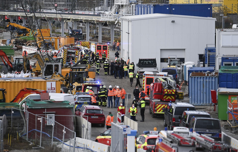 Firefighters, police officers and railway employees are seen at a railway site in Munich, Germany, Wednesday, Dec. 1, 2021. Police in Germany say three people have been injured including seriously in an explosion at a construction site next to a busy railway line in Munich. (Sven Hoppe/dpa via AP)