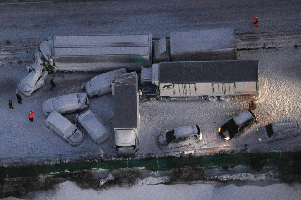 Damaged cars are covered with snow after a multiple accident on the snowy Tohoku Expressway in Osaki city, Miyagi prefecture, northern Japan, after a multiple car accident, Tuesday, Jan. 19. 2021. (Yuta Omori/Kyodo News via AP)