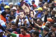 Indian cricket fans wear masks of India's captain Virat Kohli during the Cricket World Cup match between India and Pakistan at Old Trafford in Manchester, England, Sunday, June 16, 2019. (AP Photo/Dave Thompson)