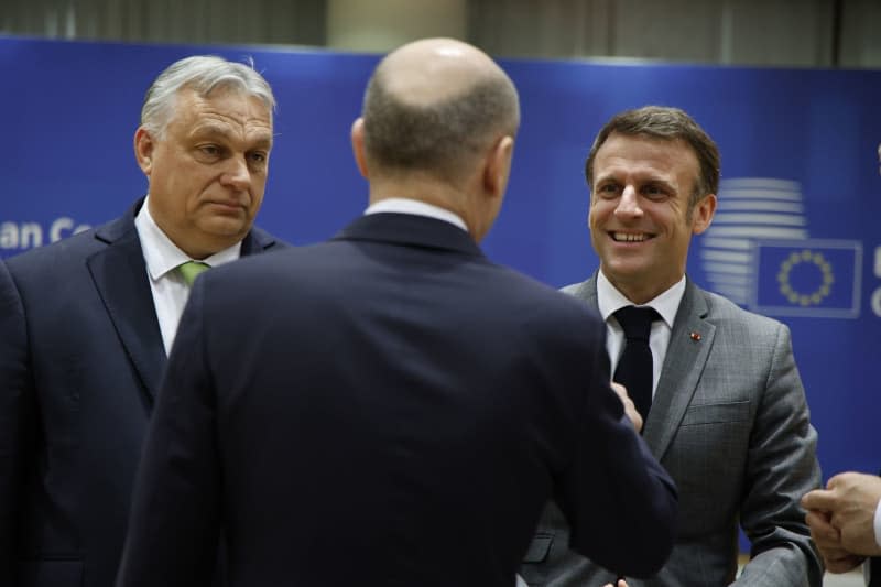 Hungarian Prime Minister Viktor Orban (L) and French President Emmanuel Macron (R) talks with German Chancellor Olaf Scholz during the EU summit in Brussels. Nicolas Maeterlinck/Belga/dpa