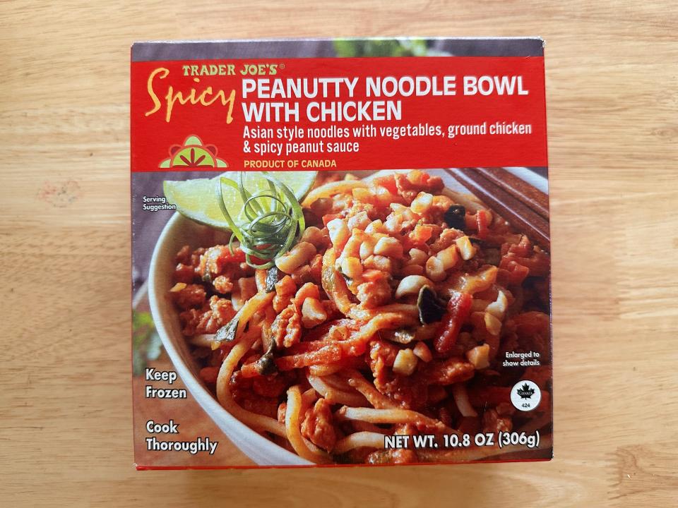 A box with a red label and white letters spelling out "Peanutty noodle bowl with chicken" and an image of a bowl of noodles with a red sauce