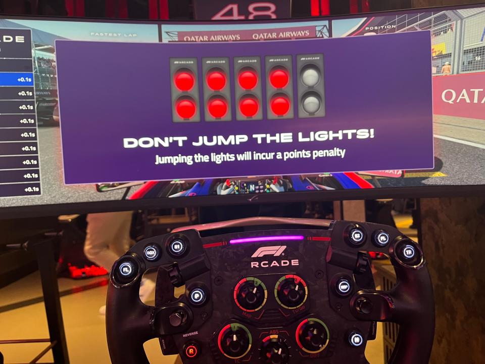 Behind the wheel for a simulated racing game at F1 Arcade.