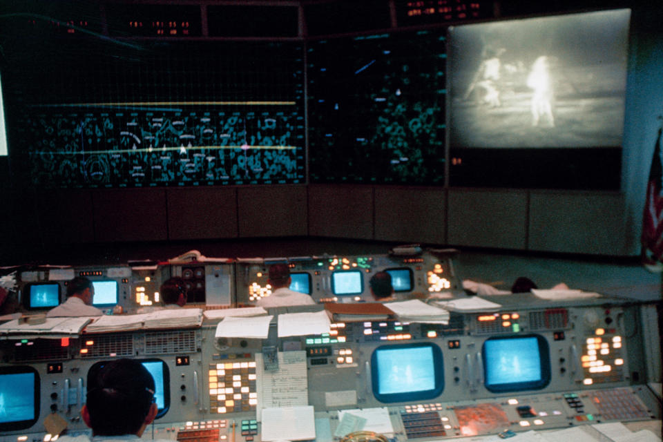 This July 20, 1969 photo made available by NASA shows the Mission Operations Control Room (MOCR) in the Mission Control Center (MCC), Building 30, during the Apollo 11 lunar extravehicular activity (EVA). The television monitor shows astronauts Neil A. Armstrong and Edwin E. Aldrin Jr. on the surface of the moon. (NASA via AP)