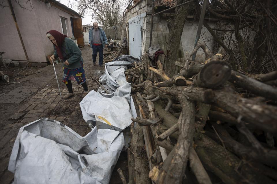 Halyna Moroka and her husband, Serhii, walk in their yard in the village of Nevelske in eastern Ukraine, Friday, Dec. 10, 2021. The 7-year-old conflict between Russia-backed separatists and Ukrainian forces has all but emptied the village. “We have grown accustomed to the shelling,” said Moroka, 84, who has stayed in Nevelske with her disabled son. (AP Photo/Andriy Dubchak)