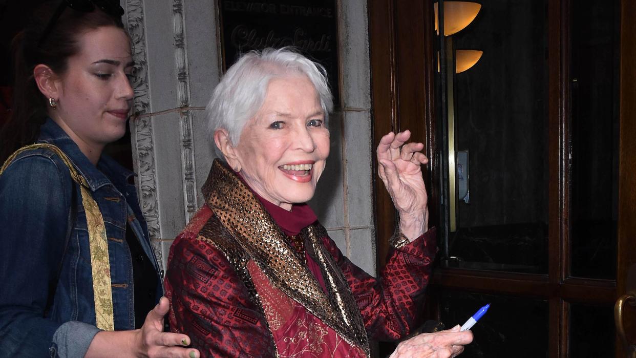 ellen burstyn smiling and waving at a photographer