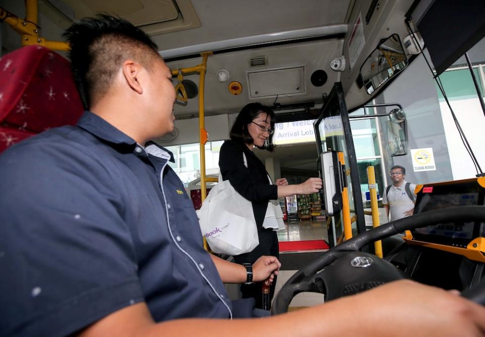 A woman uses her Touch ‘n Go card to pay for her myBas Ipoh ride at Terminal Meru Raya Ipoh January 16, 2020. — Picture by Farhan Najib