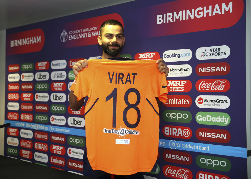 India's Virat Kohli holds up the new India shirt during the press conference at Edgbaston in Birmingham, England, Saturday June 29, 2019. India will play in new a new team shirt Sunday to avoid a clash of colours when they play England in the Cricket World Cup. (Steven Paston/PA via AP)