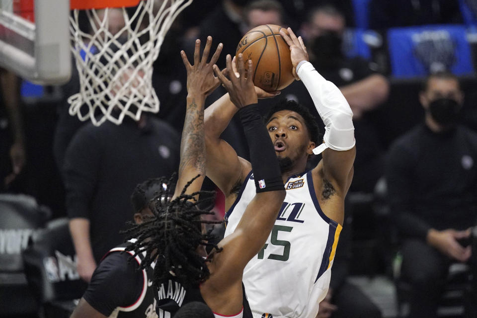 Utah Jazz guard Donovan Mitchell, right, shoots as Los Angeles Clippers guard Terance Mann defends during the first half in Game 6 of a second-round NBA basketball playoff series Friday, June 18, 2021, in Los Angeles. (AP Photo/Mark J. Terrill)