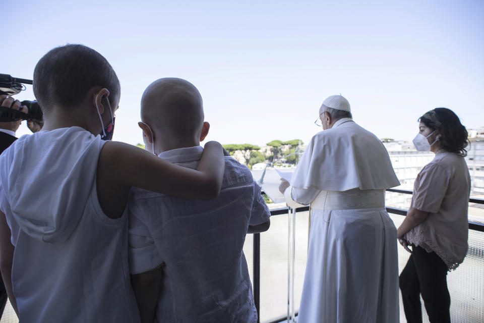 Pope Francis appears with some young oncologic patients at a balcony of the Agostino Gemelli Polyclinic in Rome, Sunday, July 11, 2021, where he was hospitalized for intestine surgery, to deliver his traditional Sunday blessing. (Vatican Media via AP)