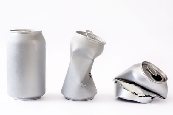 An aluminum can, a partially crushed aluminum  can, and a fully crushed aluminum  can