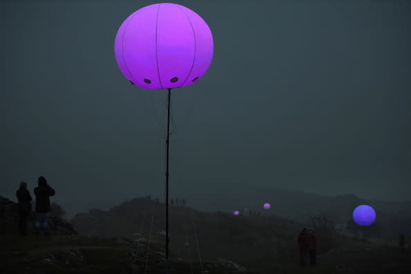 Members of the public view the art installation New York based digital arts collective YesYesNo with founding member Zachary Lieberman, Connecting Light which is part of the London 2012 Festival on August 31, 2012 in Hexham, England. Connecting Light will take place across the 73 miles of Hadrian's Wall on August 31 and September 1. Over 400 two metre diameter tethered balloons will transmit messages between each other, with internal LED lights changing colour in response. The installation becomes a line of pulsating colours as messages travel through it, turning what was once a protective border into a line of luminous communication. The installation will be visible in the evening and accessible to visitors at several locations along the wall. It has also been designed to be viewed remotely all over the world using digital media. (Photo by Jeff J Mitchell/Getty Images)