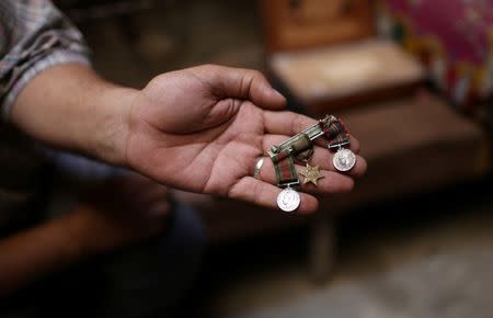 Palestinian carpenter Marwan Shahwan displays what he says are ancient objects from the British era, in Khan Younis in the southern Gaza Strip June 18, 2018. Picture taken June 18, 2018. REUTERS/Ibraheem Abu Mustafa