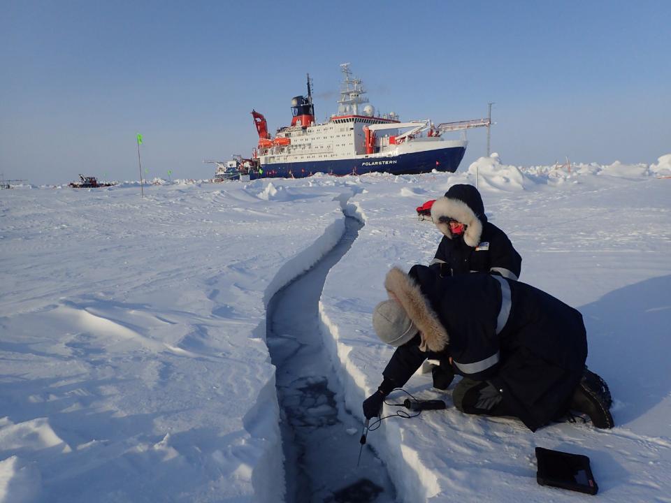 Researchers sample water for lead, with Polarstern in the background. (Photo: Torsten Sachs)