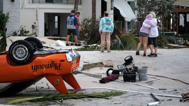 PHOTO: People embrace as they survey property damage from Hurricane Ian, Sept. 29, 2022, in Bonita Springs, Fla. (Sean Rayford/Getty Images)