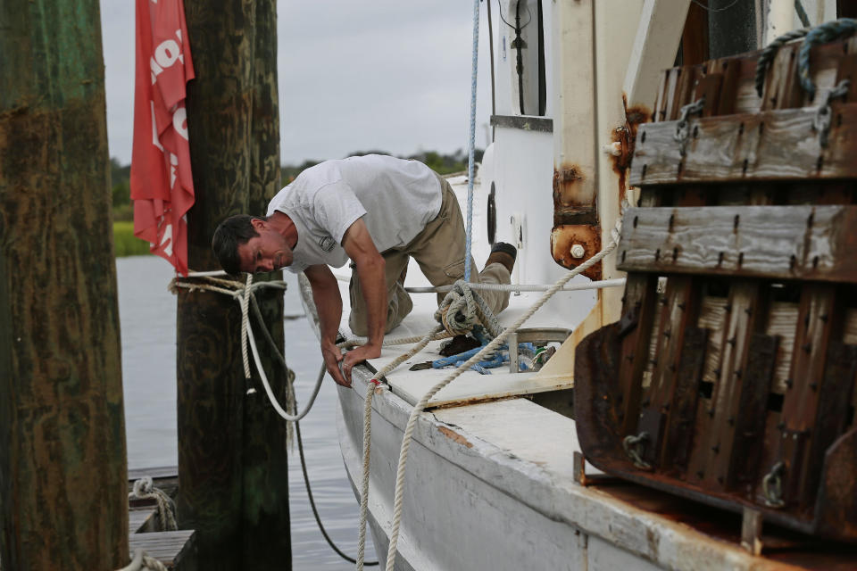 Royce Potter, a fifth generation seafood farmer, suveys the damage to his fishing vessel following the effects of Hurricane Isaias in Southport, N.C., Tuesday, Aug. 4, 2020. Potter spent the night on his docked boat. (AP Photo/Gerry Broome)