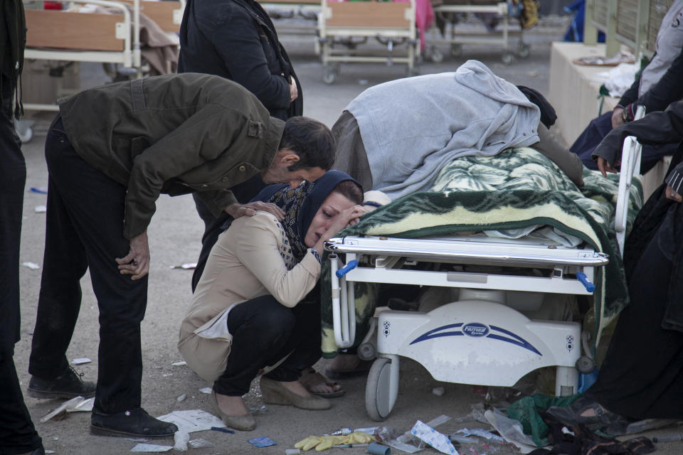 <p>In this photo provided by Tasnim News Agency, relatives weep over the body of an earthquake victim, in Sarpol-e-Zahab, western Iran, Nov. 13, 2017. (Photo: Farzad Menati/Tasnim News Agency via AP) </p>