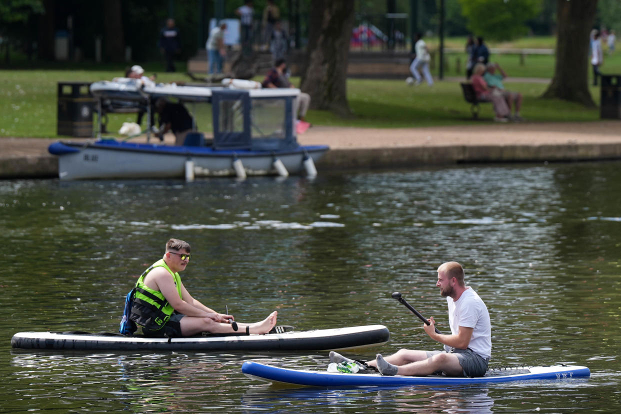 Men on paddle boards travel along the river in Stratford-upon-Avon.