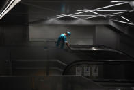 An employee wearing a protective mask to help curb the spread of the coronavirus cleans the handrail of an escalator at the underneath of a subway station Thursday, July 29, 2021, in Tokyo. (AP Photo/Eugene Hoshiko)