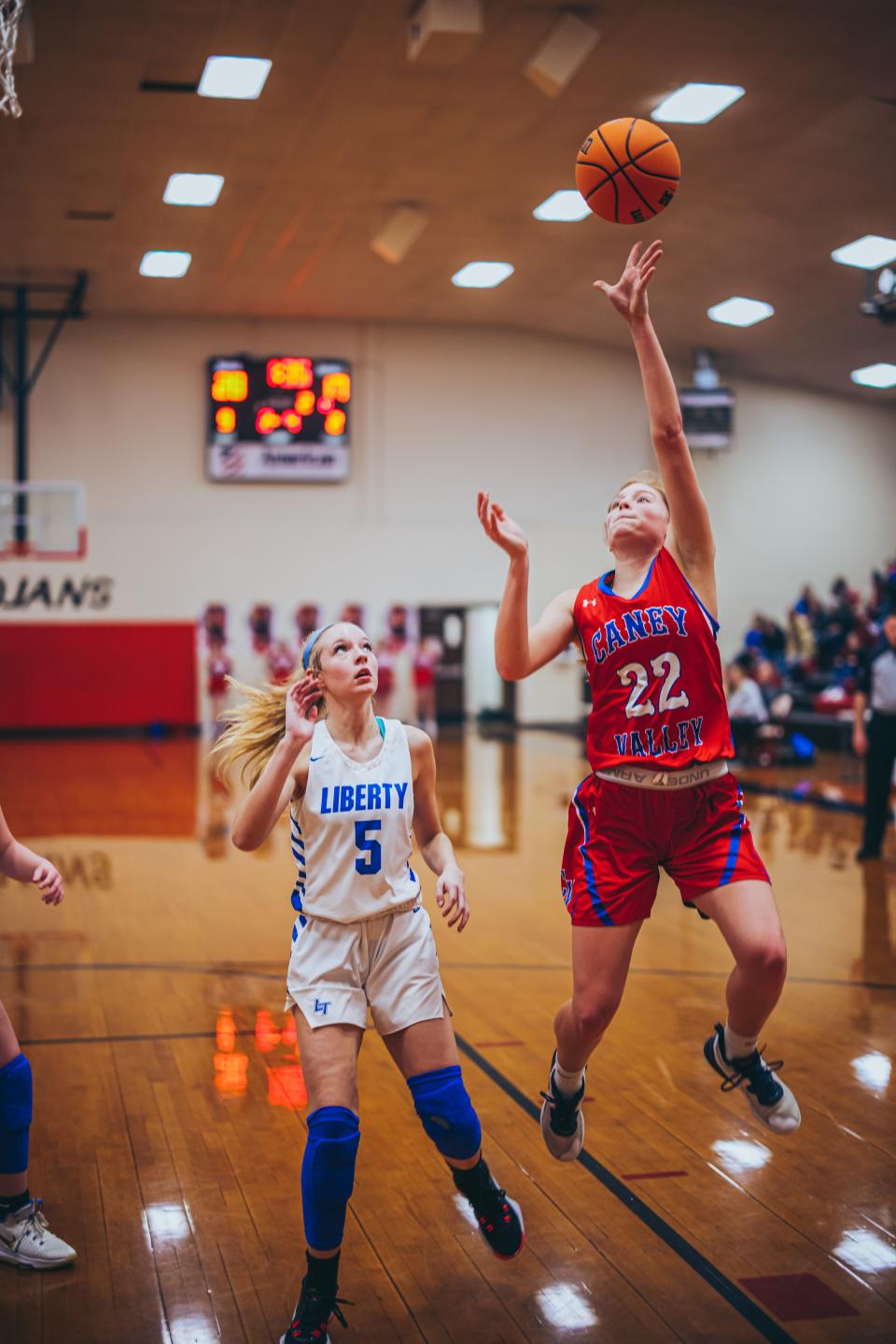 Caney Valley's Lauren Rutherford fights in the lane with Liberty's Jennika Boone during Thursday night's game.