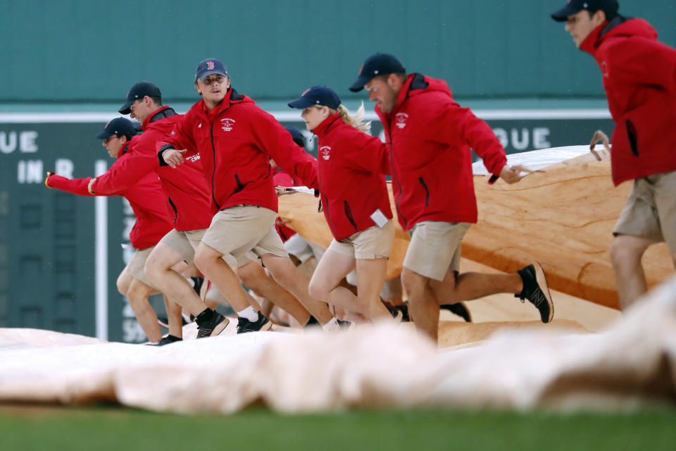 The Fenway Park grounds crew brings out the tarp before a baseball game between the Boston Red Sox and the the Tampa Bay Rays, Friday, June 2, 2023, in Boston. (AP Photo/Michael Dwyer)