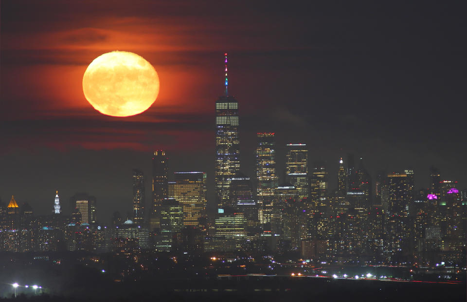 The strawberry moon rises above the skyline of lower Manhattan and One World Trade Center in New York City on June 25, 2021 as seen from Verona, New Jersey. / Credit: Gary Hershorn / Getty Images