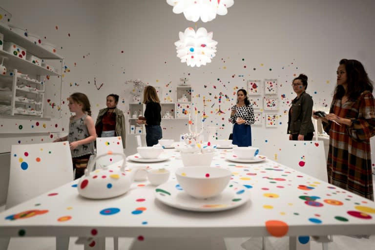 People place dot stickers in the obliteration room during the Kusama exhibition at the Hirshhorn Museum on February 23, 2017 in Washington, DC