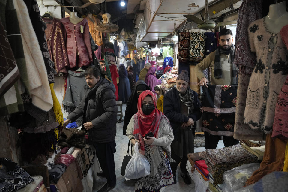 People visit a market for shopping in Lahore, Pakistan, Wednesday, Jan. 4, 2023. Authorities on Wednesday ordered shopping malls and markets to close by 8:30 p.m. as part of a new energy conservation plan aimed at easing Pakistan's economic crisis, officials said. The move comes amid talks with the International Monetary Fund. (AP Photo/K.M. Chaudary)