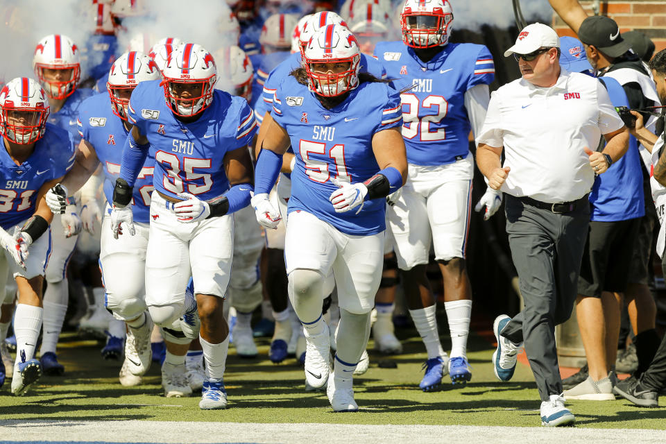 SMU head coach Sonny Dykes leads the team onto the field before a game against Temple. (Getty)