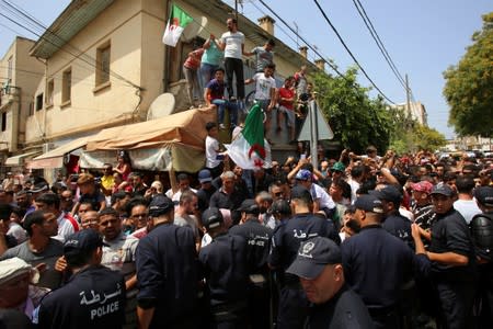 Police officers and guard ad people gather outside El Harrach prison in Algiers