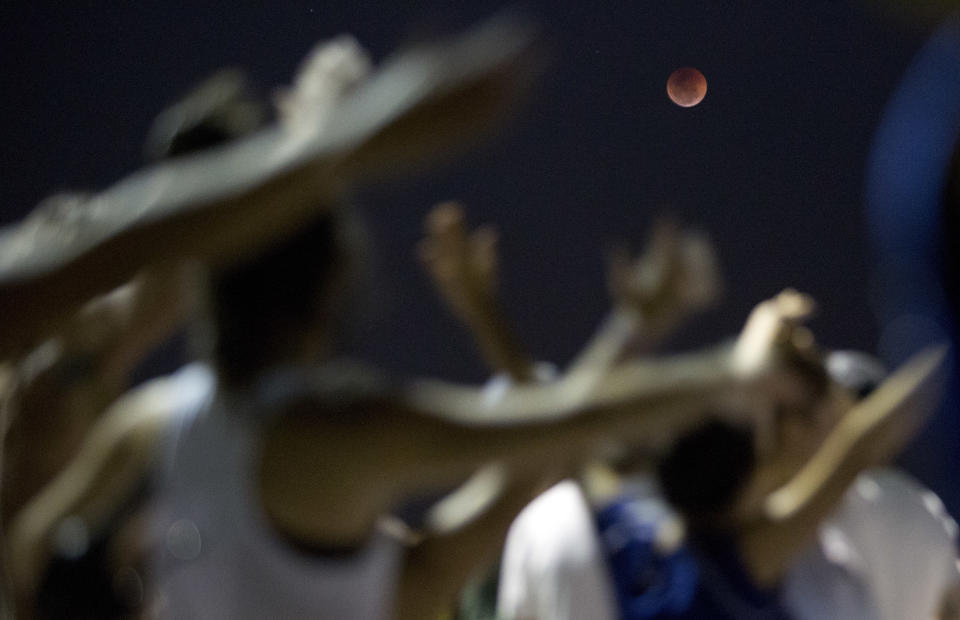 <p>A blood moon rises at Arpoador beach in Rio de Janeiro, Brazil, Friday, July 27, 2018. (Photo: Silvia Izquierdo/AP) </p>