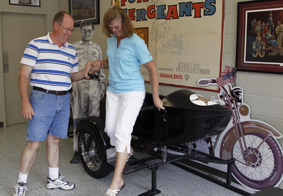 FILE - This July 3, 2012 file photo shows Kevin Mixon helping his wife Donna Gail Mixon, of Walterboro, S.C., from a sidecar in the Andy Griffith Museum in Mount Airy, N.C. Tourism in Mount Airy is up since Andy Griffith died July 3, with about 10,400 people visiting the Andy Griffith Museum in July, almost double the 5,400 who visited in July 2011. (AP Photo/Gerry Broome, file)