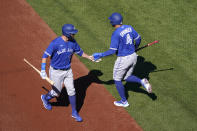 Toronto Blue Jays' George Springer (4) is congratulated by teammate Alejandro Kirk after scoring during the first inning of an opening day baseball game against the St. Louis Cardinals Thursday, March 30, 2023, in St. Louis. (AP Photo/Jeff Roberson)