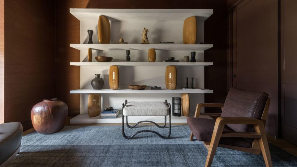 a chair and a shelf in a room with a white wall