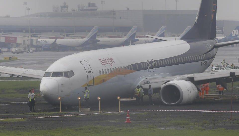 A domestic flight that skidded off the main runway late Monday night during heavy monsoon rains is seen at the Mumbai airport in Mumbai, India, Tuesday, July 2, 2019. Heavy monsoon rains in western India caused at least three walls to collapse onto huts and city shanties, killing more than two dozen people and injuring dozens of others, officials said Tuesday, as forecasters warned of more rains. (AP Photo/Rafiq Maqbool)