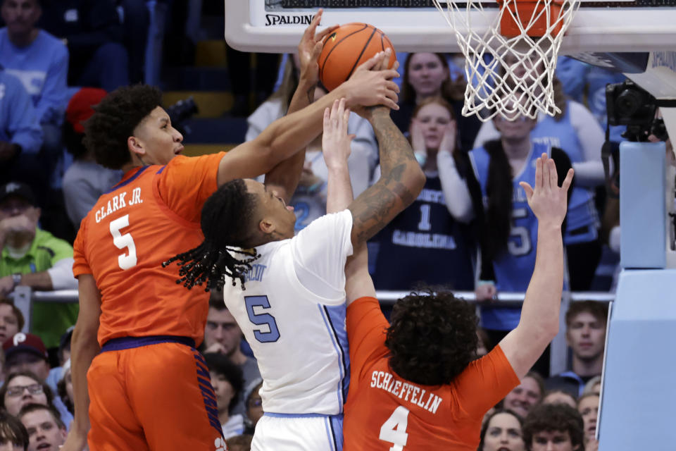 Clemson forwards Jack Clark, left, and Ian Schieffelin (4) and North Carolina forward Armando Bacot, center, work under the basket during the second half of an NCAA college basketball game Tuesday, Feb. 6, 2024, in Chapel Hill, N.C. (AP Photo/Chris Seward)