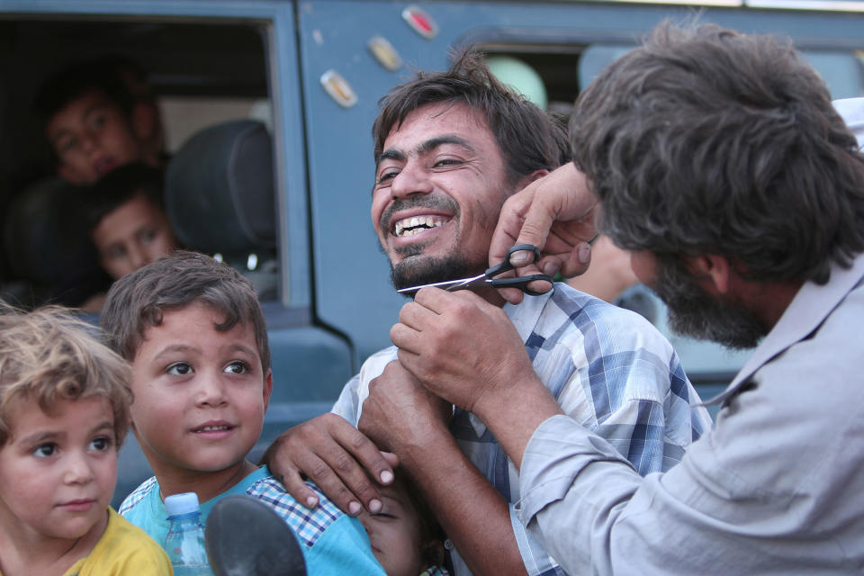 <p>A man cuts the beard of a civilian who was evacuated with others by the Syria Democratic Forces (SDF) fighters from an Islamic State-controlled neighbourhood of Manbij, in Aleppo Governorate, Syria, Aug. 12, 2016. (REUTERS/Rodi Said) </p>