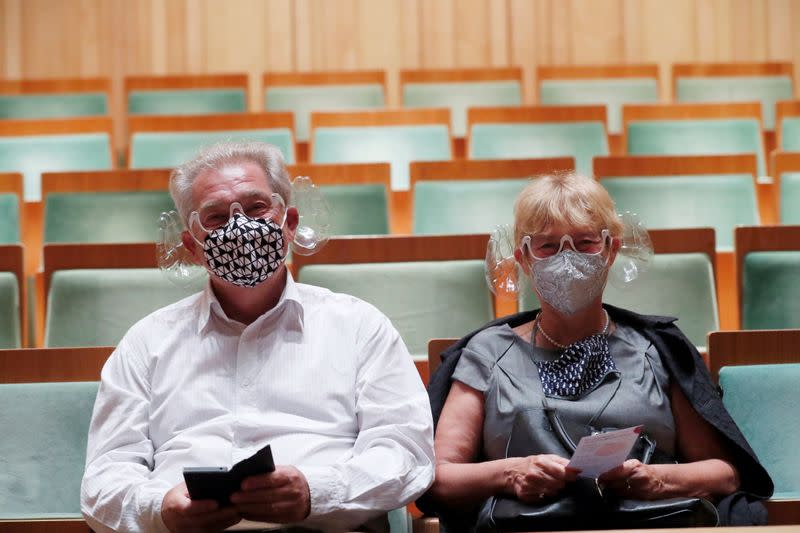 A couple wears orchestra conductor Ivan Fischer's acoustic mask at the Mupa Budapest