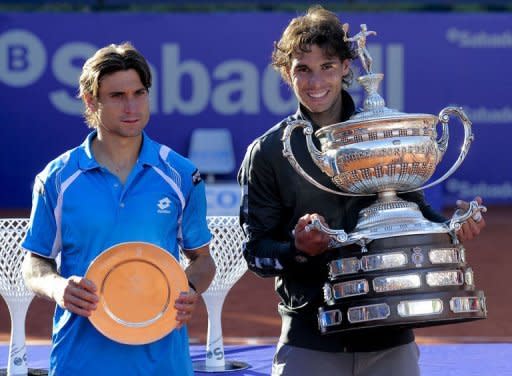 Rafael Nadal (R) celebrates with the trophy after winning the final of the Barcelona Open tennis tournament Conde de Godo against compatriot David Ferrer. Nadal won 7-6, 7-5