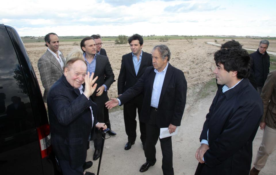 In this photo released by the Madrid Regional Government on May 6, 2012, CEO of Las Vegas Sands Corp. Sheldon Adelson, left in foreground, waves while visiting Alcorcon, which was one of the possible sites for the EuroVegas project on the outskirts of Madrid, with others unidentified. It is announced Sept. 7, 2012, casino giant Las Vegas Sands Corp. has chosen Madrid over Barcelona for a multi-billion dollar gambling resort project dubbed "EuroVegas". With Supporters point out the prospects of construction jobs and service casino jobs will bring improvement to the high jobless rate and shrinking economy in Spain, but critics predict that gambling will attract criminals. (AP Photo/Comunidad de Madrid)