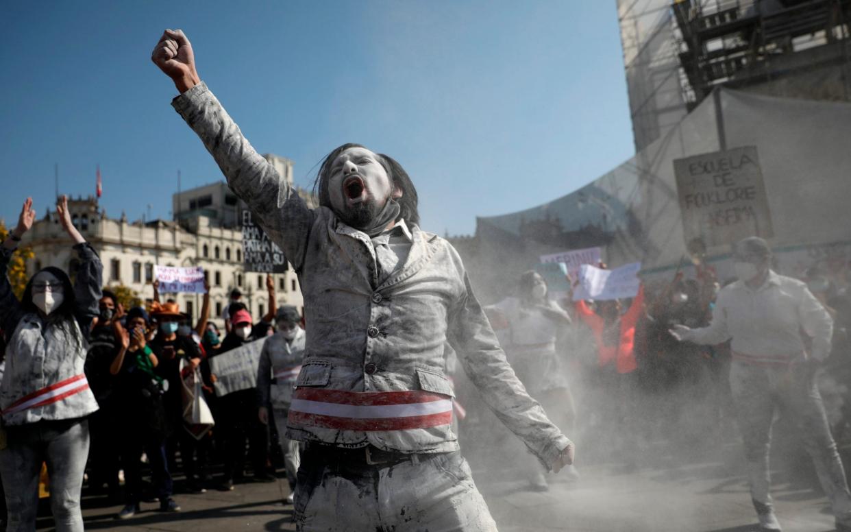 A man dressed as a zombie wears a presidential sash, to represent himself as a minister of Peru's newly sworn-in president, gets revved up in San Martin plaza where people who are refusing to recognise the new government gather to protest in Lima, Peru - AP