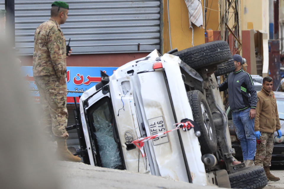 Lebanese soldiers stand next to a turned over UN peacekeeper vehicle at the scene where a UN peacekeeper convoy came under gunfire in Al-Aqbiya village, south Lebanon, Thursday, Dec. 15, 2022. (AP Photo/Mohammed Zaatari)