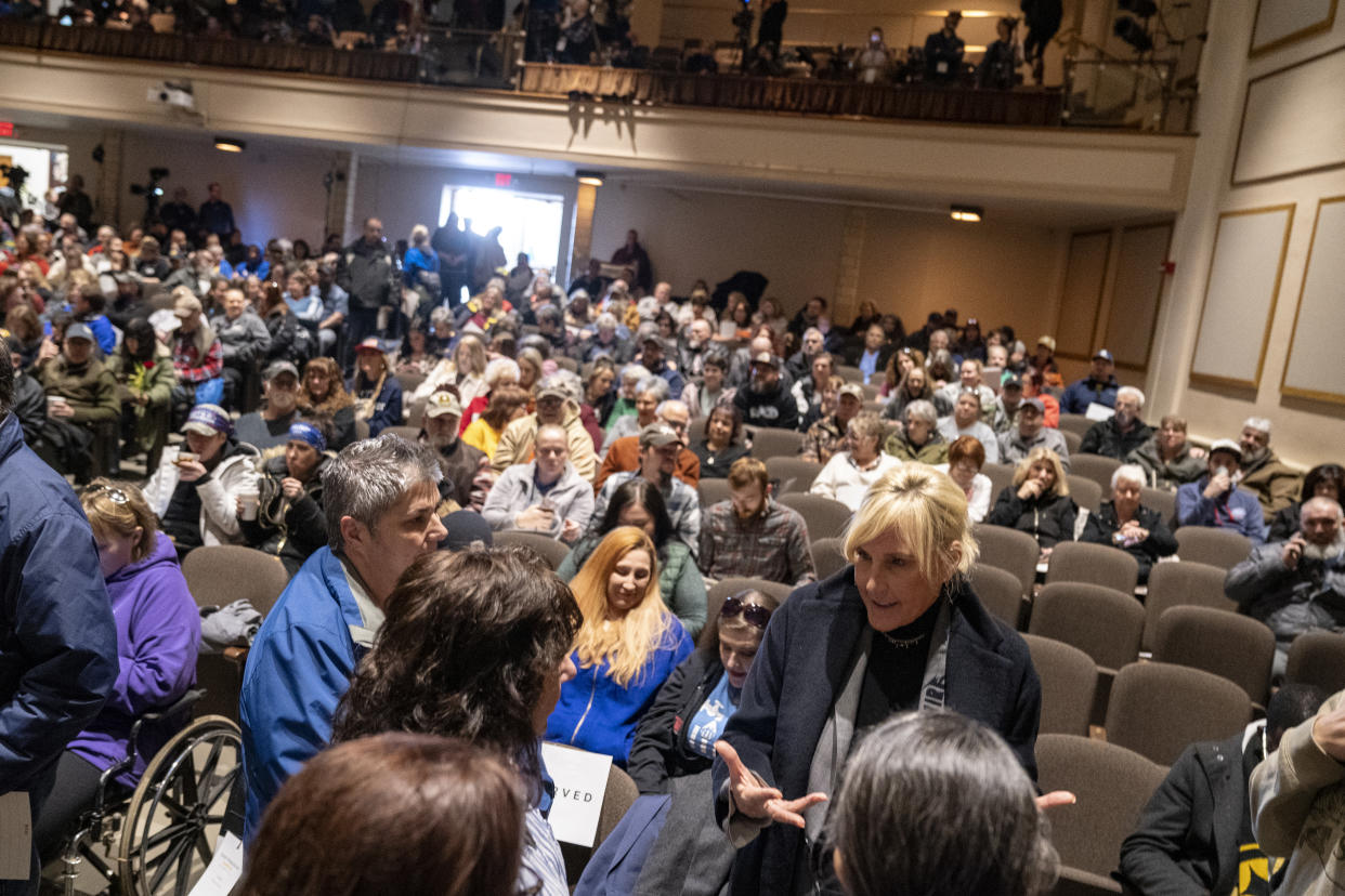 In an auditorium filled with people, Erin Brockovich sits in one of the front rows speaking to residents.