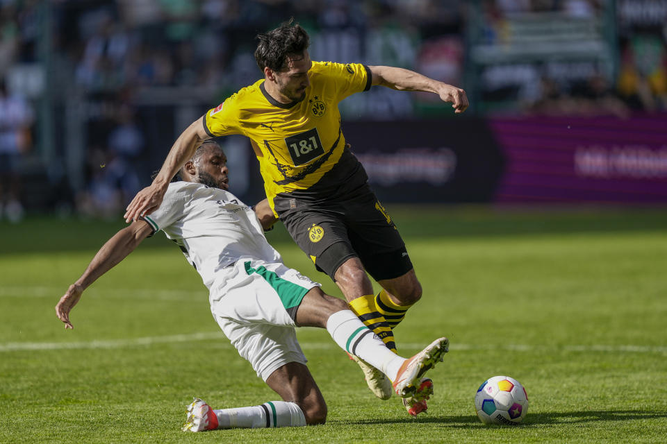 Moenchengladbach's Jordan Pefok, left, and Dortmund's Mats Hummels challenge for the ball during the German Bundesliga soccer match between Borussia Moenchengladbach and Borussia Dortmund at the Borussia Park in Moenchengladbach, Germany, Saturday, April 13, 2024. (AP Photo/Martin Meissner)