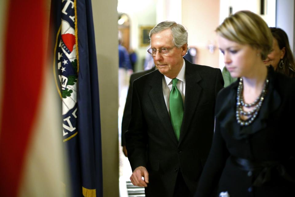 U.S. Senate Minority Leader Mitch McConnell (R-KY) (C) returns to his office after a vote to raise the debt ceiling at the U.S. Capitol in Washington February 12, 2014. Legislation to extend U.S. federal borrowing authority for a year cleared a critical procedural hurdle in the Senate on Wednesday, moving the measure to a final vote. REUTERS/Jonathan Ernst (UNITED STATES - Tags: POLITICS BUSINESS)