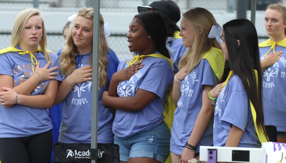 Volunteer students take part in the national anthem during the Gaston County Special Olympics Spring Games held Friday morning, May 6, 2022, at Stuart Cramer High School.