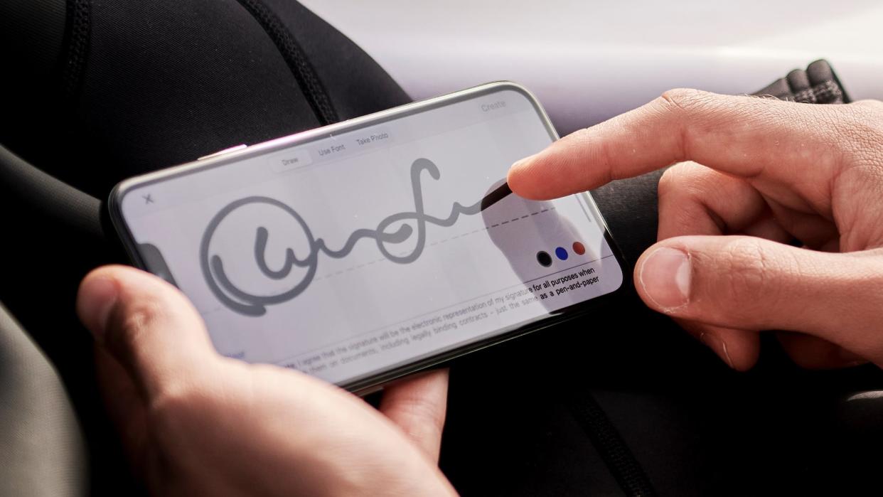 A person signing a PDF document on their phone