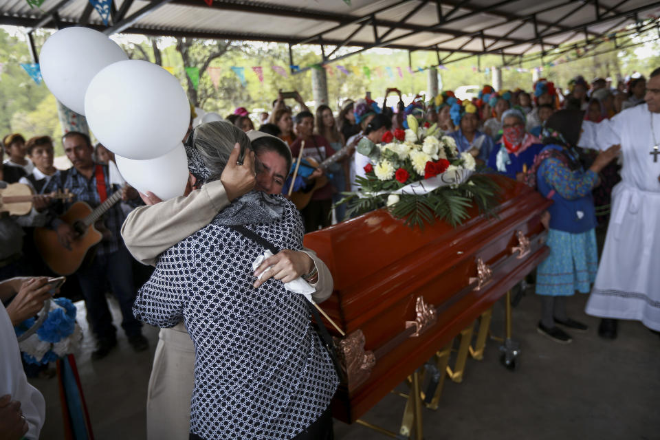 A nurse is comforted by a woman during the funeral procession of Jesuit priests Javier Campos Morales and Joaquin Cesar Mora Salazar in Creel, Chihuahua state, Mexico, Sunday, June 26, 2022. The two elderly priests and a tour guide murdered in Mexico's Sierra Tarahumara this week are the latest in a long line of activists, reporters, travelers and local residents who have been threatened or killed by criminal gangs that dominate the region. (AP Photo/Christian Chavez)